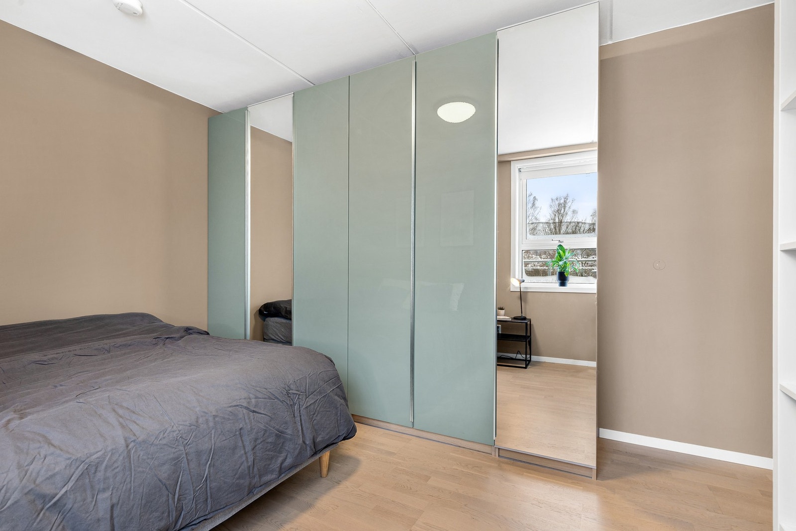 Hovedsoverommet har god plass til dobbeltseng og nattbord, og det er god oppbevaringsplass i en stor skyvedørsgarderobe Galleribilde