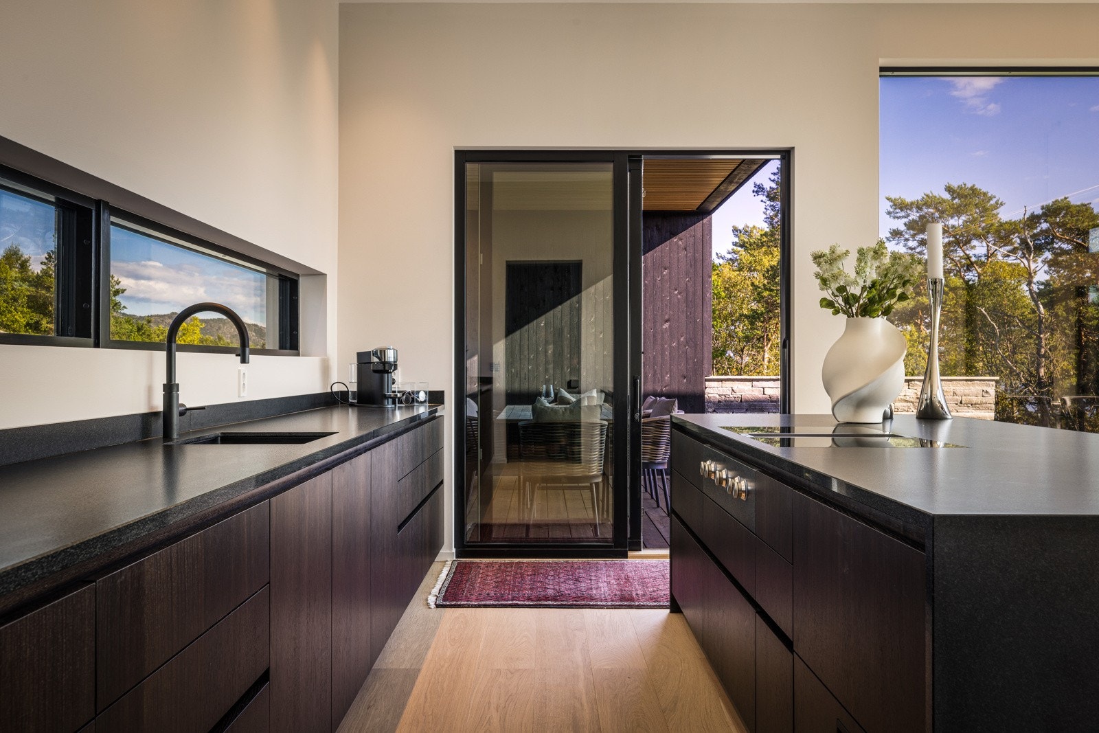 - Kjøkkenets benkeplate er av matt, sort granitt med underlimt vask og armatur fra Dornbracht, med coocker som gir både varmt, kaldt og kullsyre vann - Galleribilde