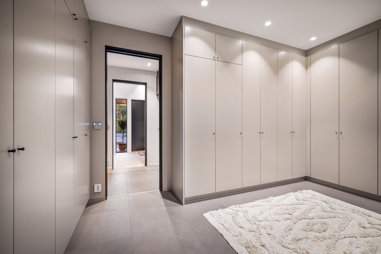 - Gjennom gjestegarderoben finner man en svært stor og funksjonell garderobe med plassbygde skap i malt ask - Galleribilde