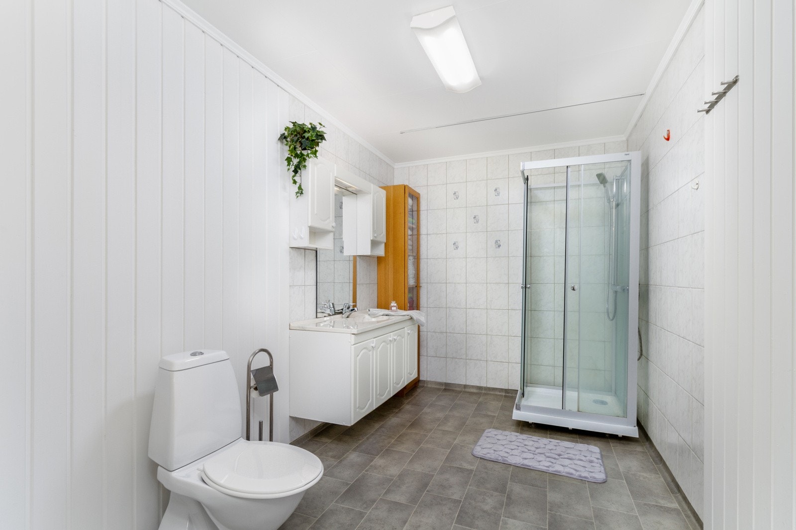 Baderommet er på 8,5 kvm og er innredet med toalett, servantskap med oppbevaringsplass og dusjkabinett. Galleribilde