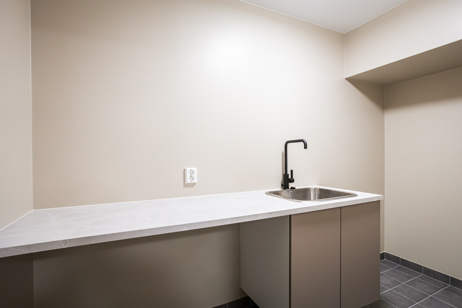 Praktisk vaskerom i underetasjen med innredning. Det er god plass til vaskemaskin og tørketrommel. Galleribilde