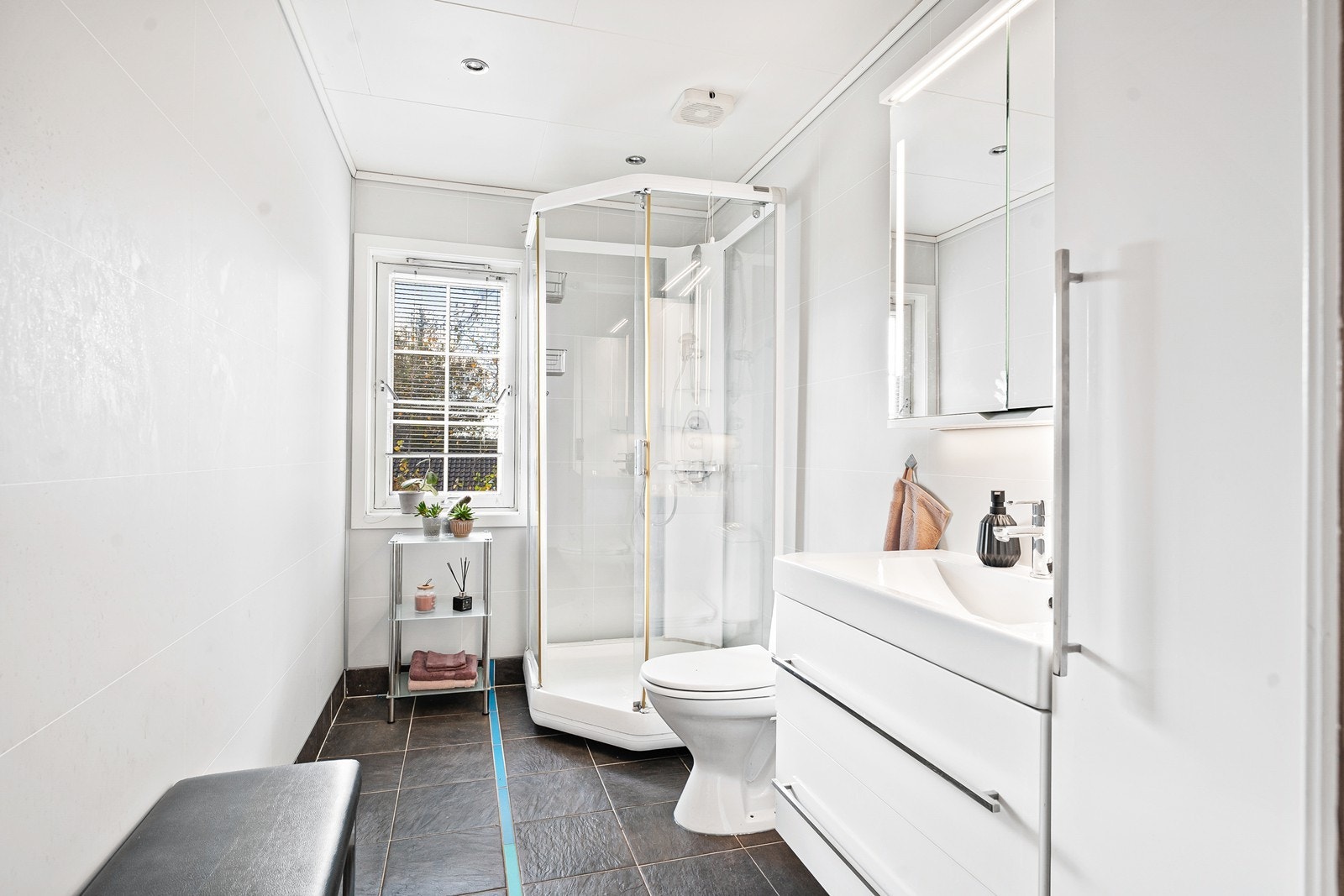 Badet i overetasjen har flisbelagt gulv med varmekabler. Baderomsplater på veggene og moderne baderomsinnredning ble oppgradert i 2013. Galleribilde