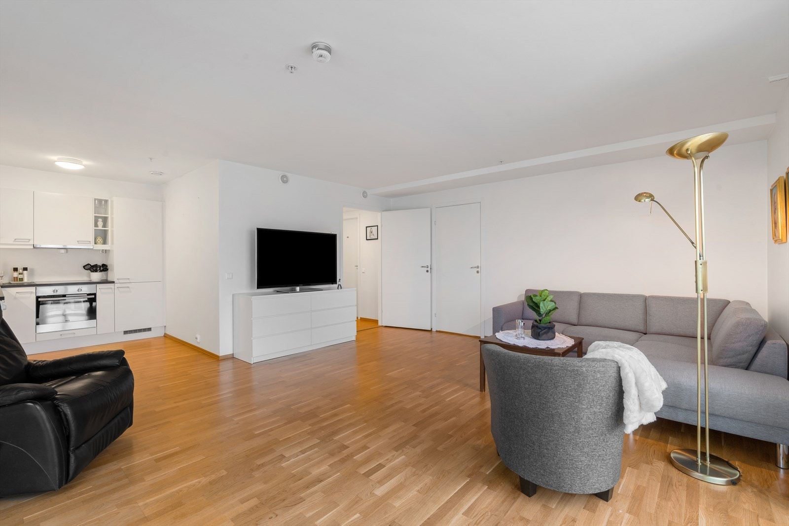 Rommelig stue med åpen løsning til lyst, moderne kjøkken Galleribilde