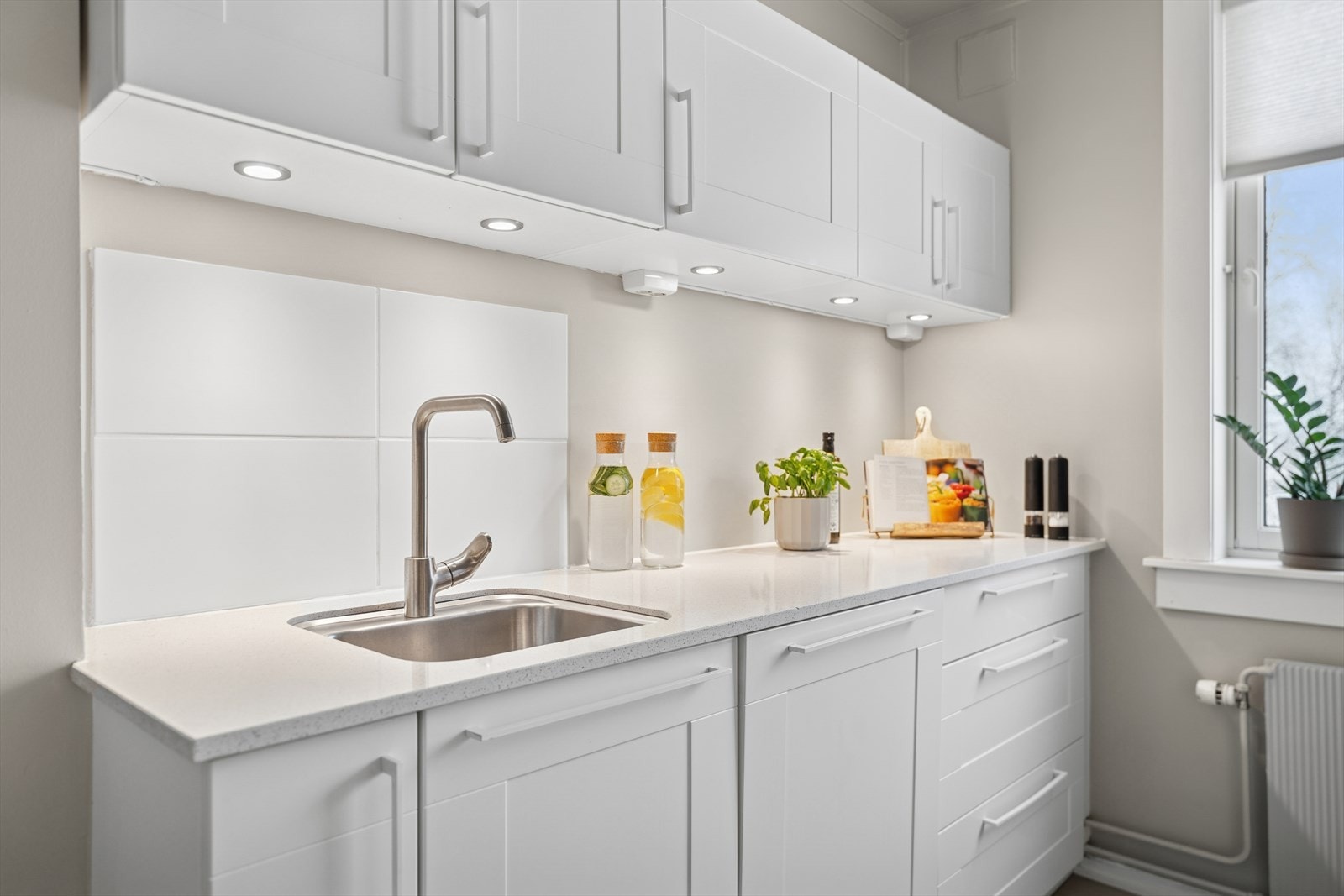 Kvik kjøkkeninnredning fra 2015. Innredet med folierte fronter og kvarts benkeplate. Galleribilde