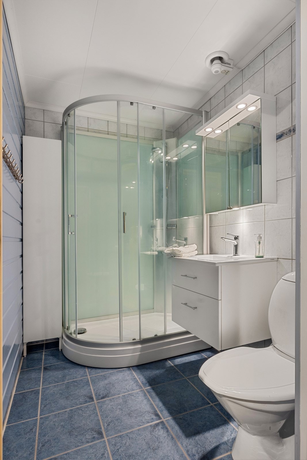 Badet har flislagt gulv med varmekabler og tidløs innredning. For klesvask er det eget vaskerom i rommet ved siden av. Galleribilde