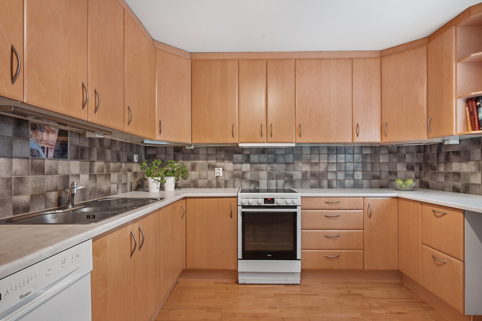 Kjøkkeninnredningen fra 2004 har godt med oppbevaringsplass i over- og underskap med slette fronter og benkeplate i laminat. Galleribilde