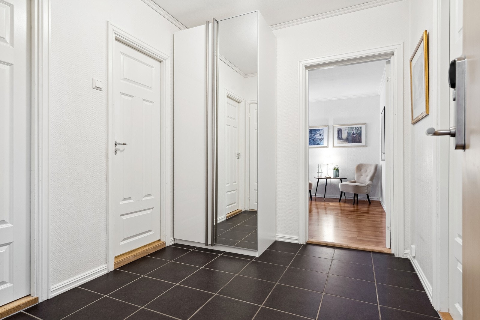 Innbydende entre med flislagt gulv og rom for garderobeskap. Galleribilde