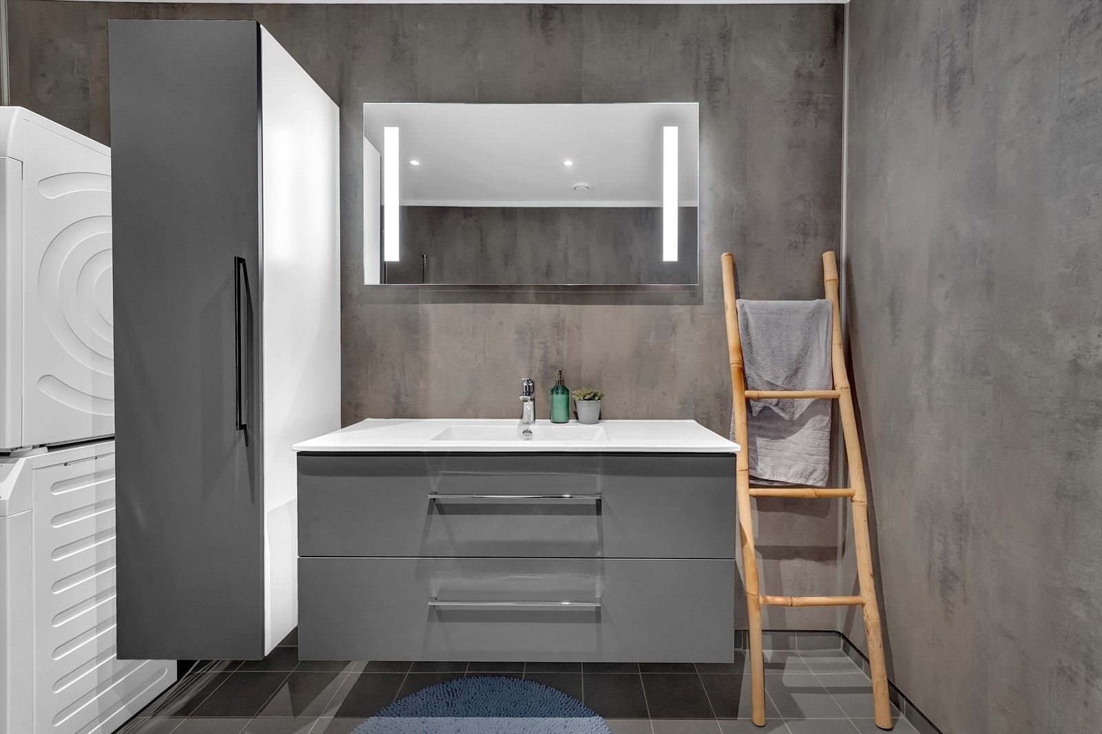 Her er det toalett, dusjhjørne med innfellbare glassdører, servantinnredning og opplegg for vaskemaskin. Galleribilde