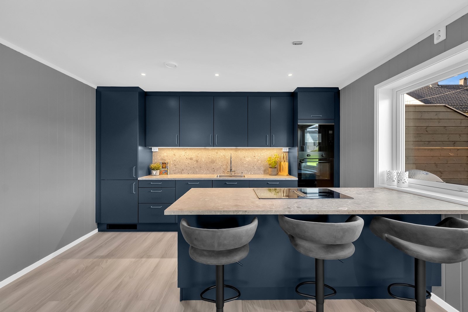 Pent kjøkken med moderne tilvalg - Mørke fronter og laminert benkeplate, med integrerte hvitevarer. Galleribilde