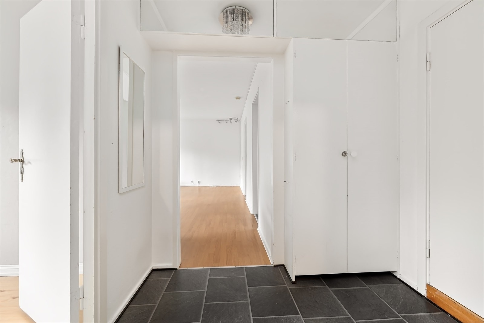 Entré med garderobeskap og laminatfliser på gulv. Galleribilde
