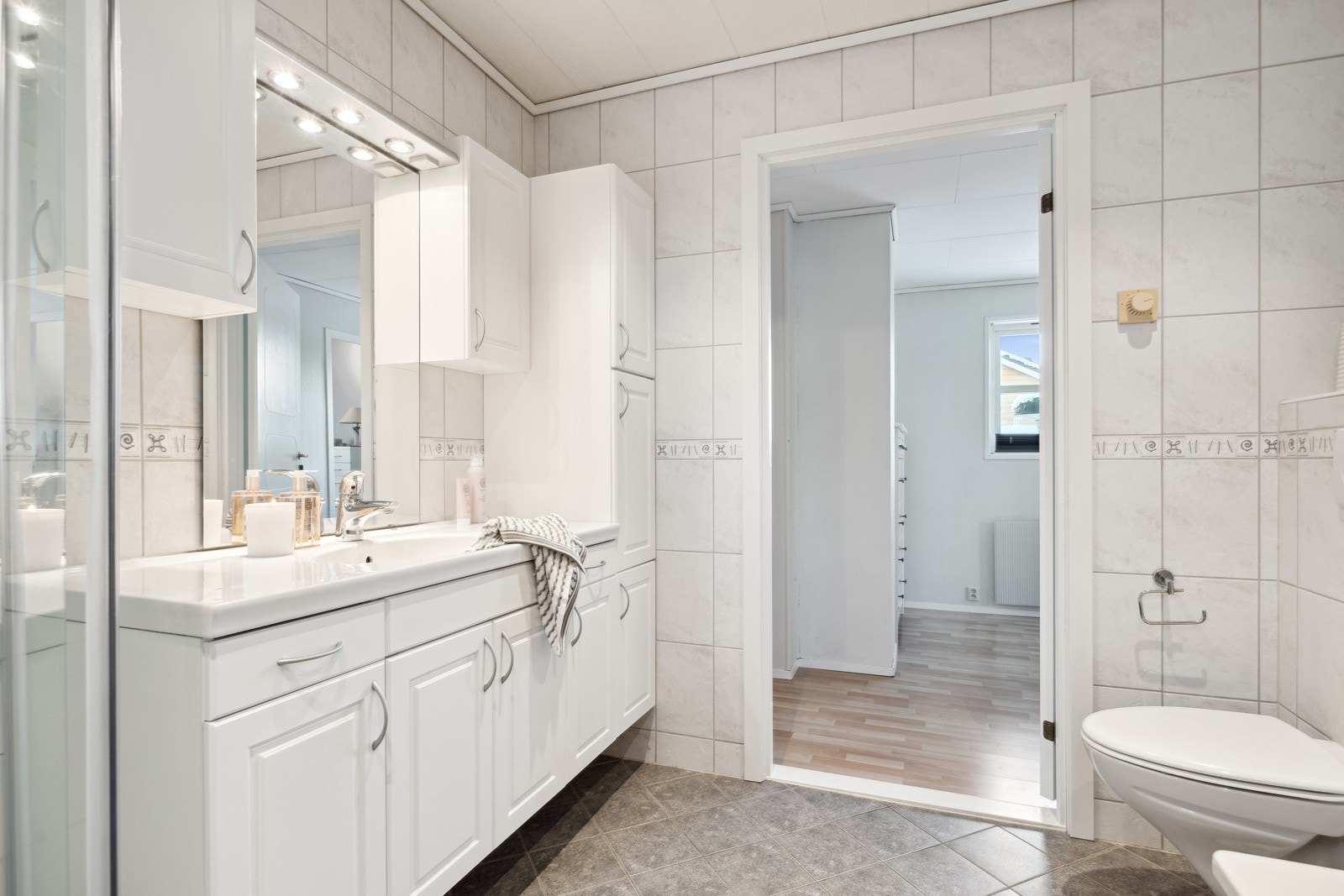 Badet i 2. etasje er utstyrt med vegghengt servantinnredning, skap, dusjkabinett, badekar og vegghengt toalett. Galleribilde