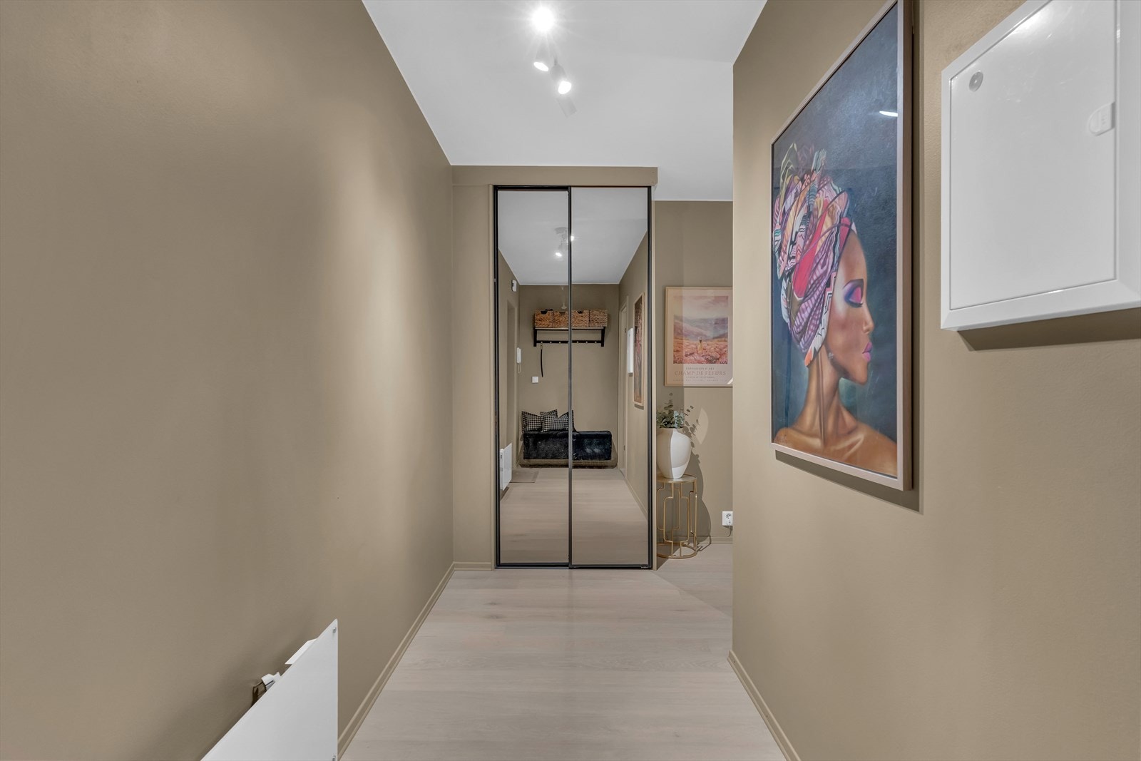 Leiligheten har en svært romslig entré med god plass til å henge fra seg yttertøy og sette fra seg sko. Det er montert et praktisk garderobeskap med skyvedører i glass. Galleribilde