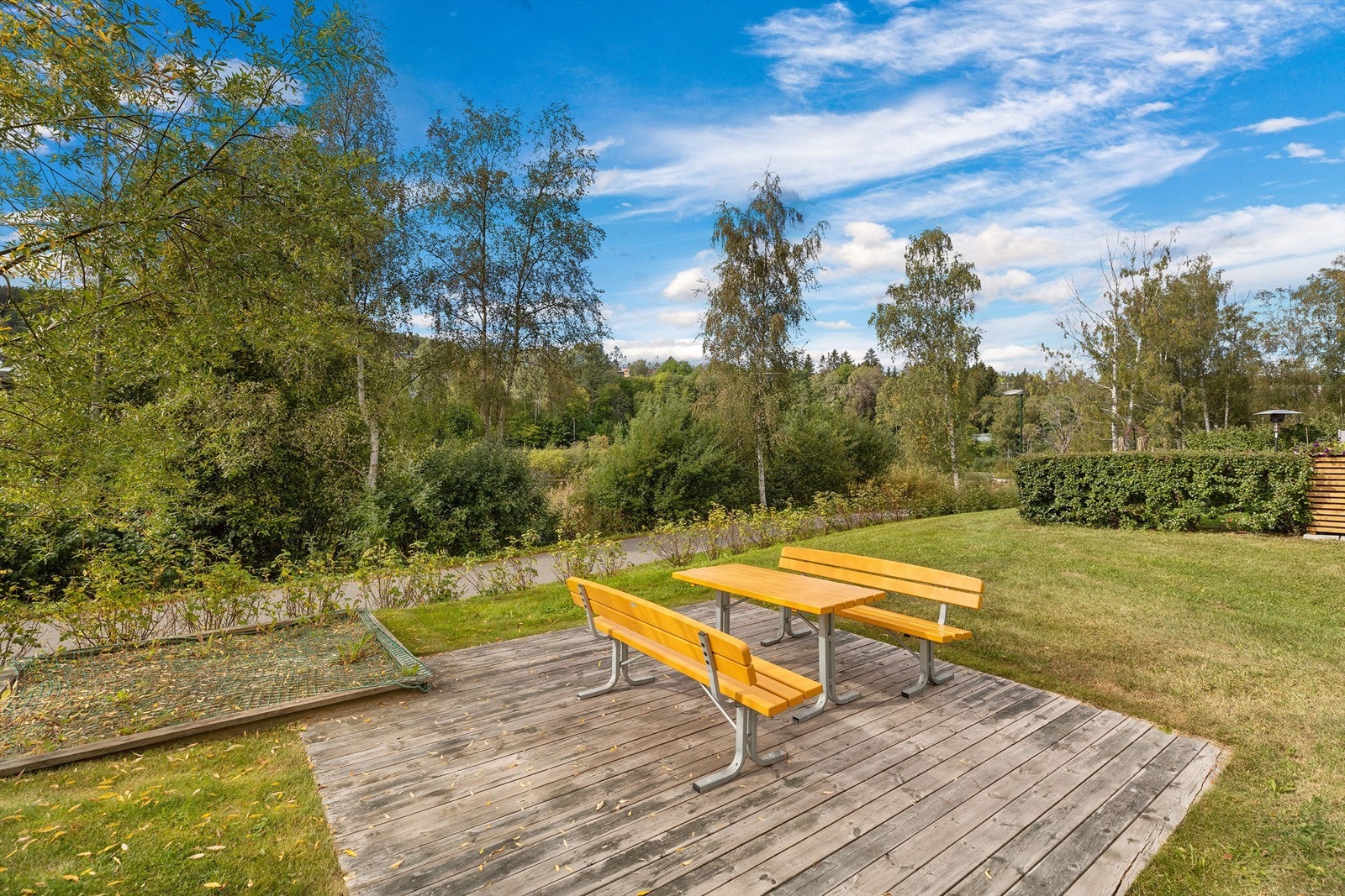 Felles tomt for sameiet opparbeidet med benker, asfalterte internveier, gressplen, prydbusker og diverse beplantning. Galleribilde