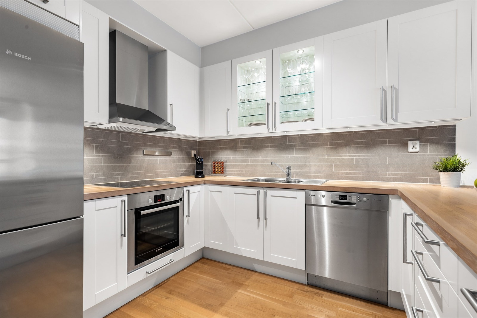 Benkeskapsbelysning og stikkontakter over kjøkkenbenk. Vegghengt ventilator. Galleribilde