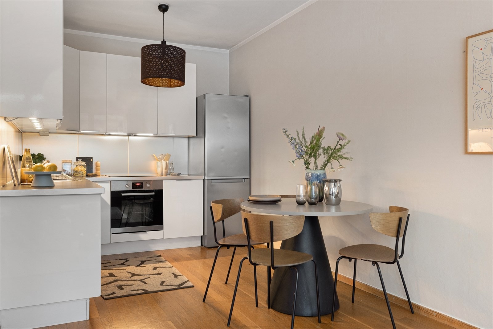 Lys innredning fra Ikea med glatte fronter og sprutplate mellom benk over overskap. Galleribilde