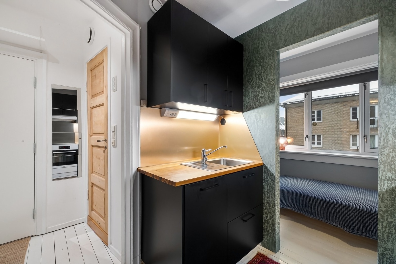 Innredningen har glatte fronter i svart utførelse og benkeplate av heltre med nedfelt kum i rustfritt stål. Galleribilde