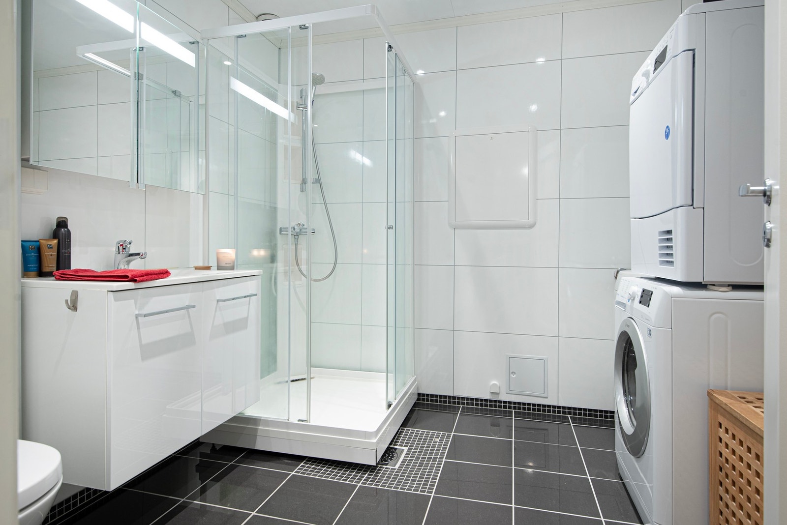Stort og moderne bad med opplegg for vaskemaskon og tørketrommel. Galleribilde