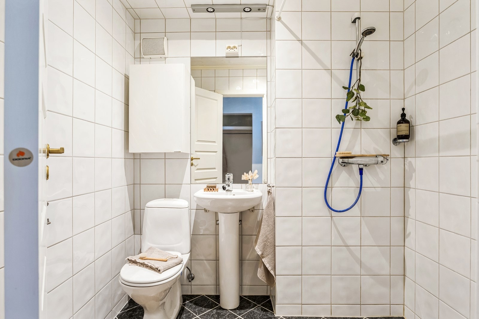 Eldre helfliset bad med søylevask, dusjsone med forheng og toalett. I tillegg er det behagelig gulvvarme Galleribilde