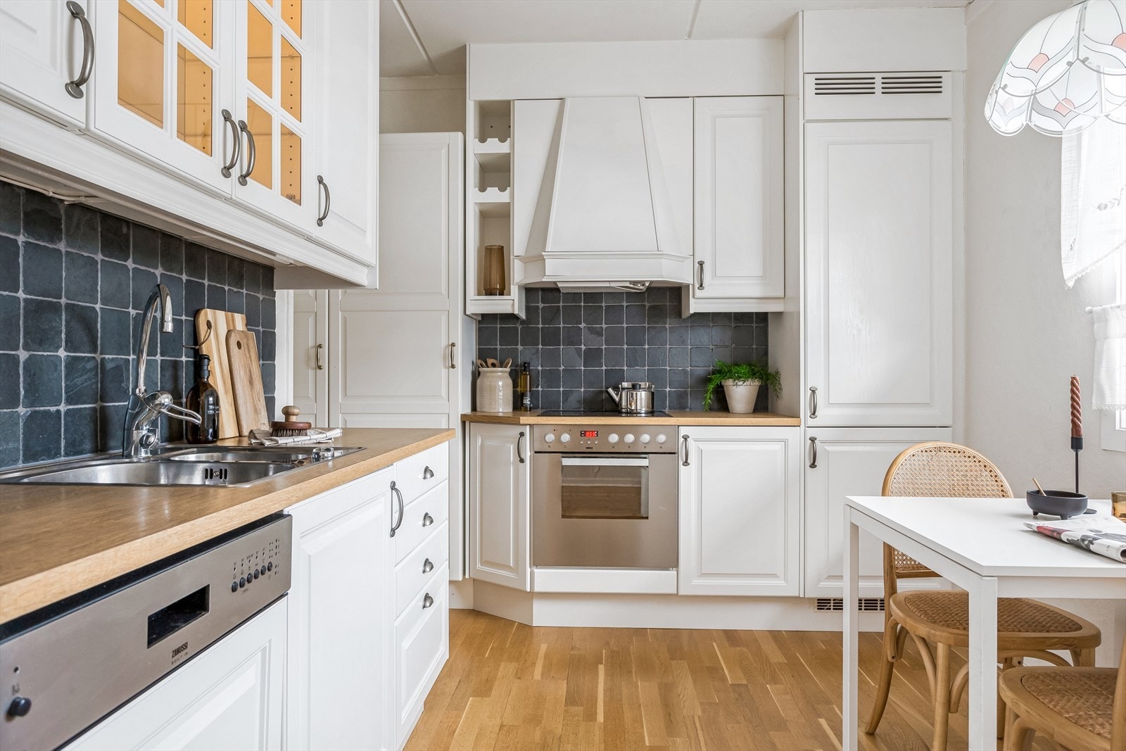 Kjøkken med profilerte fronter, benkeplater av laminat og fliser på vegg over benk Galleribilde