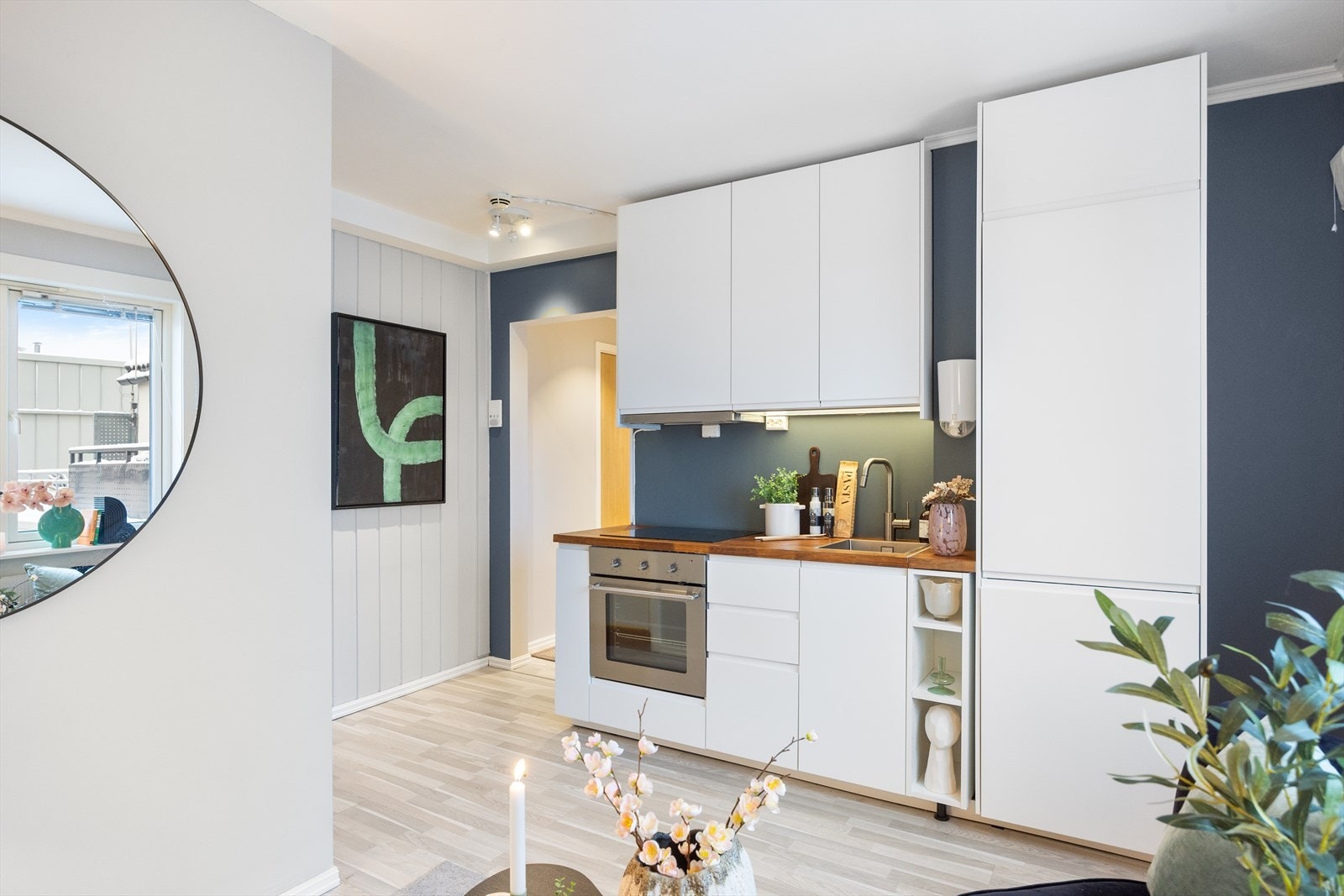 Her finner du en tidsriktig kjøkkeninnredning med hvitevarer, inkludert komfyr med induksjonstopp og kjøleskap med fryser. Galleribilde