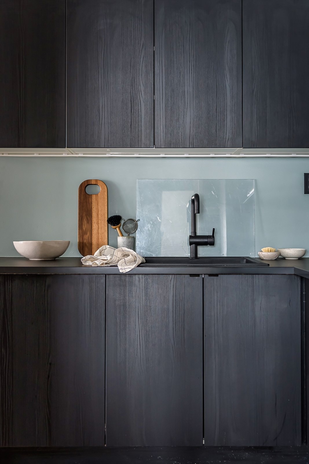 De mørke frontene balanserer fargevalgene i leiligheten og skaper en fin kontrast Galleribilde