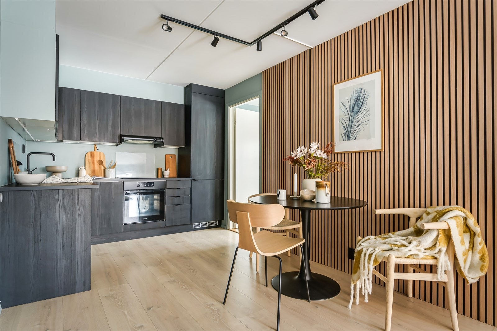 En lekker spilevegg gir en fin kontrast og en naturlig avgrensning mellom stue og kjøkken Galleribilde