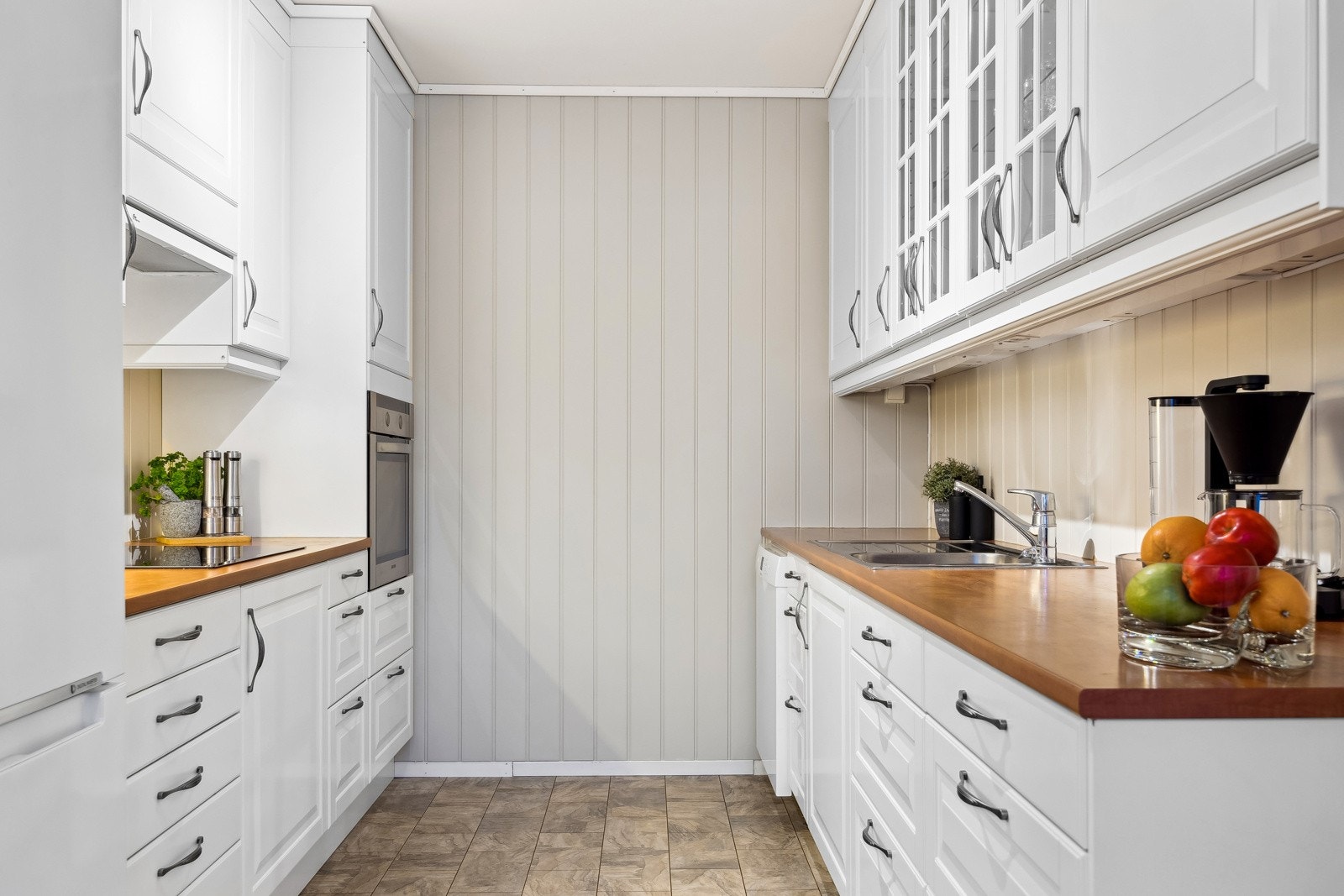 Kjøkkenet har en tidløs innredning med hvite, profilerte fronter. Galleribilde