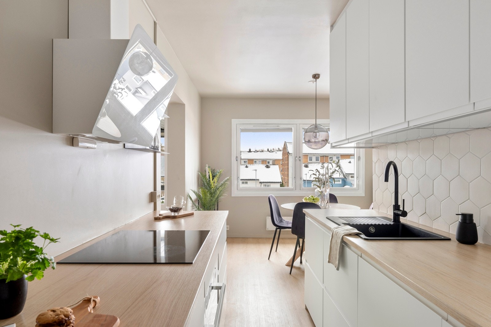 Over den ene benken er det beige heksagonfliser, og over kokesonen er en hvit ventilator installert Galleribilde