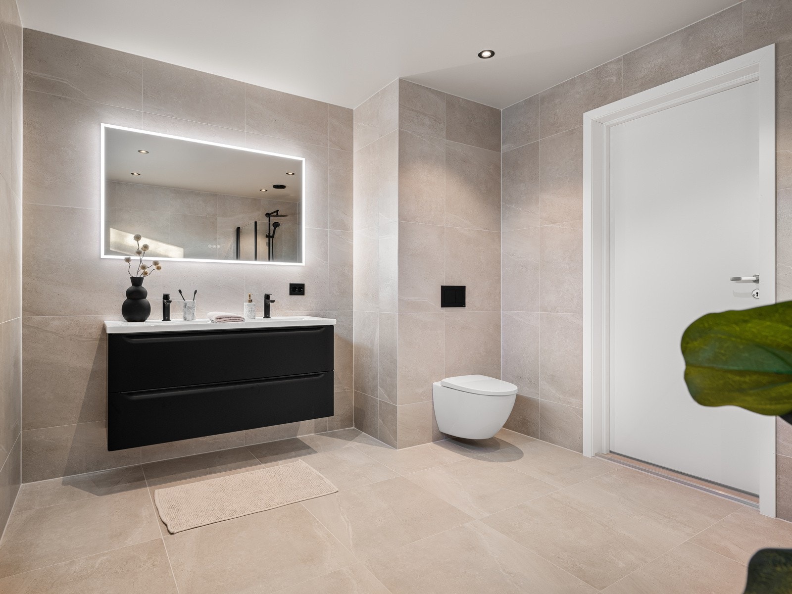 Badet er innredet med baderomsinnredning med dobbel vask, speil med belysning, veggheng toalett, og dusj Galleribilde