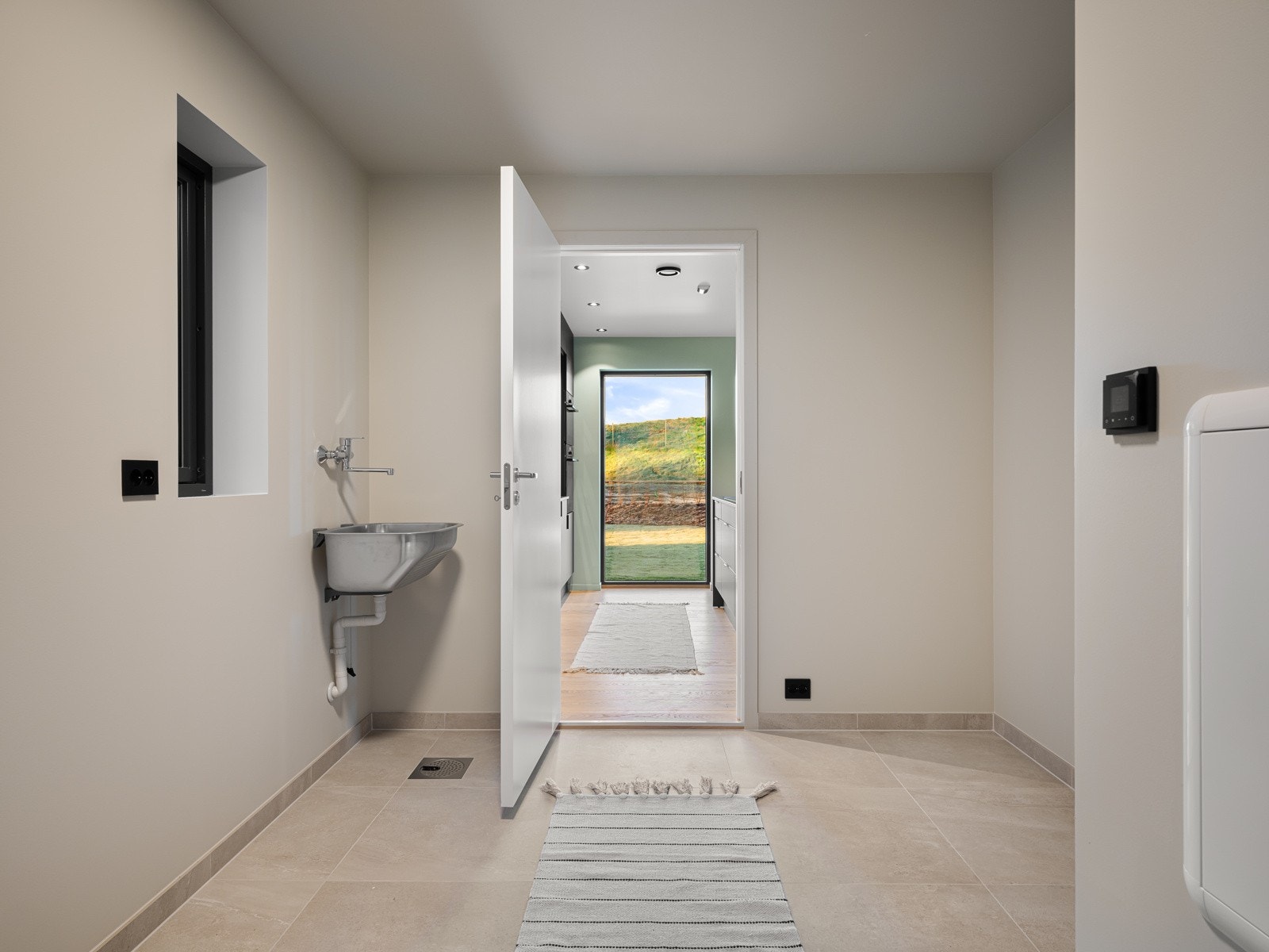 Praktisk bi-inngang/vaskerom med flotte 60x60 fliser på gulvet og malte vegger Galleribilde