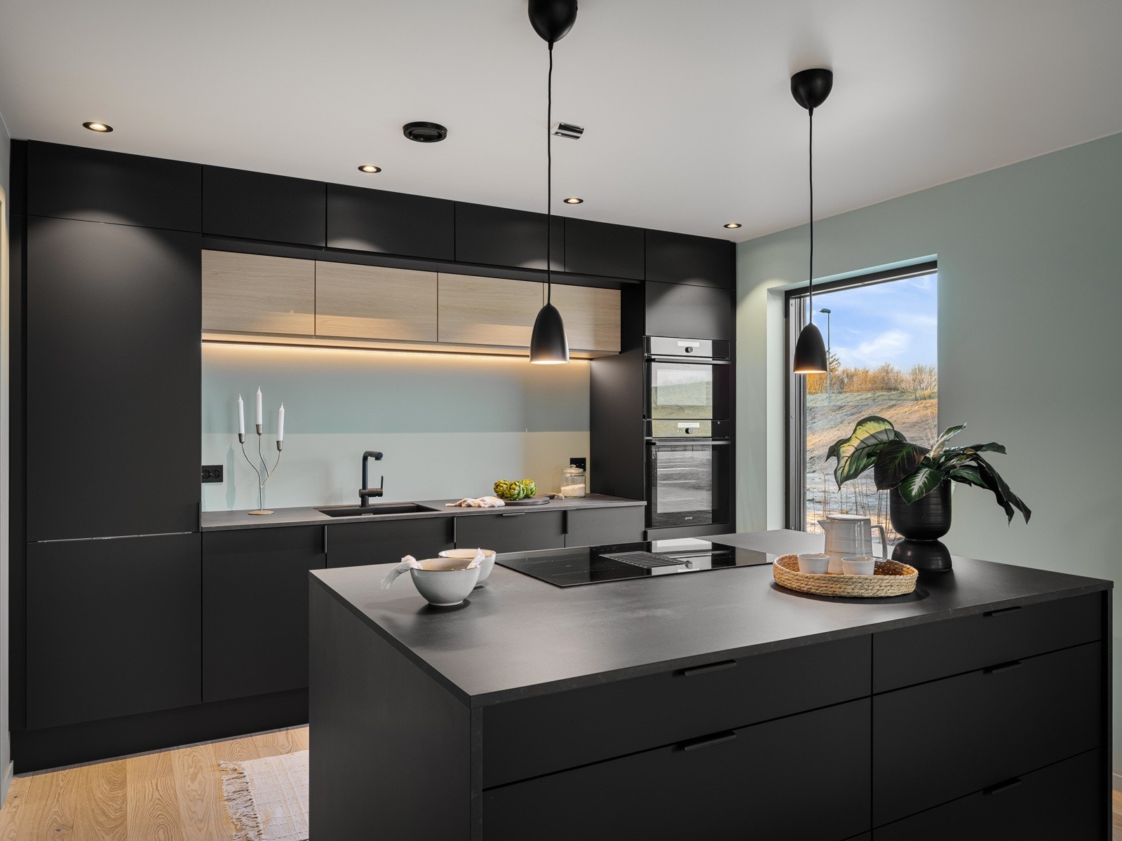 Et elegant og funksjonelt kjøkken fra JKE-Design med mørke, tidløse fronter og en praktisk kjøkkenøy Galleribilde