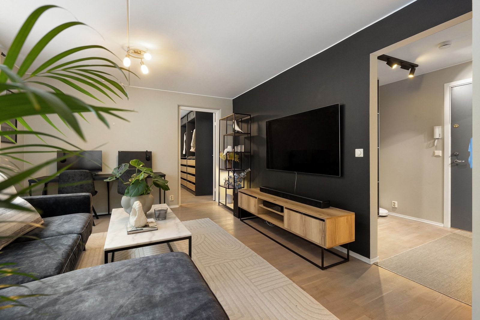 Veggene er malt i tidsriktige, harmoniske fargetoner, hvor en mørkere kontrastvegg tilfører dybde og et moderne uttrykk. Galleribilde