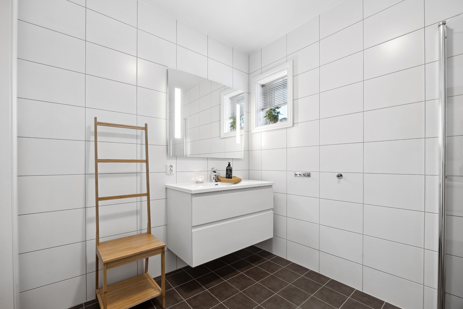 Pent baderom med vegghengt innredning. Innredningen har heldekkende servant. Galleribilde