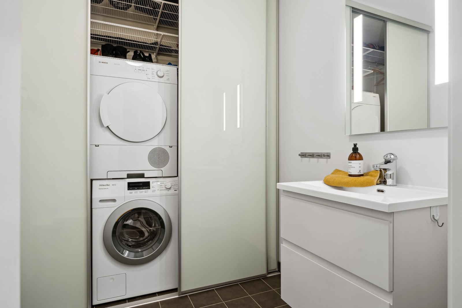 Vaskemaskin og tørketrommel er praktisk skjult bak skyvedører på vaskerommet. Galleribilde