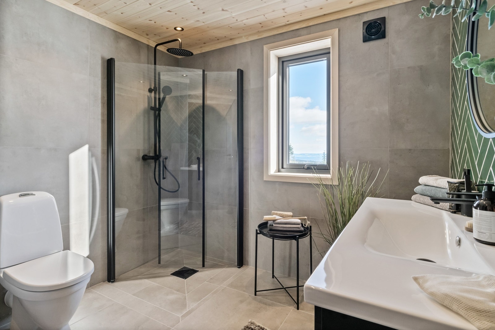 Hytta har et meget lekkert, flislagt bad med panel i himlingen og elektriske varmekabler i gulvet Galleribilde