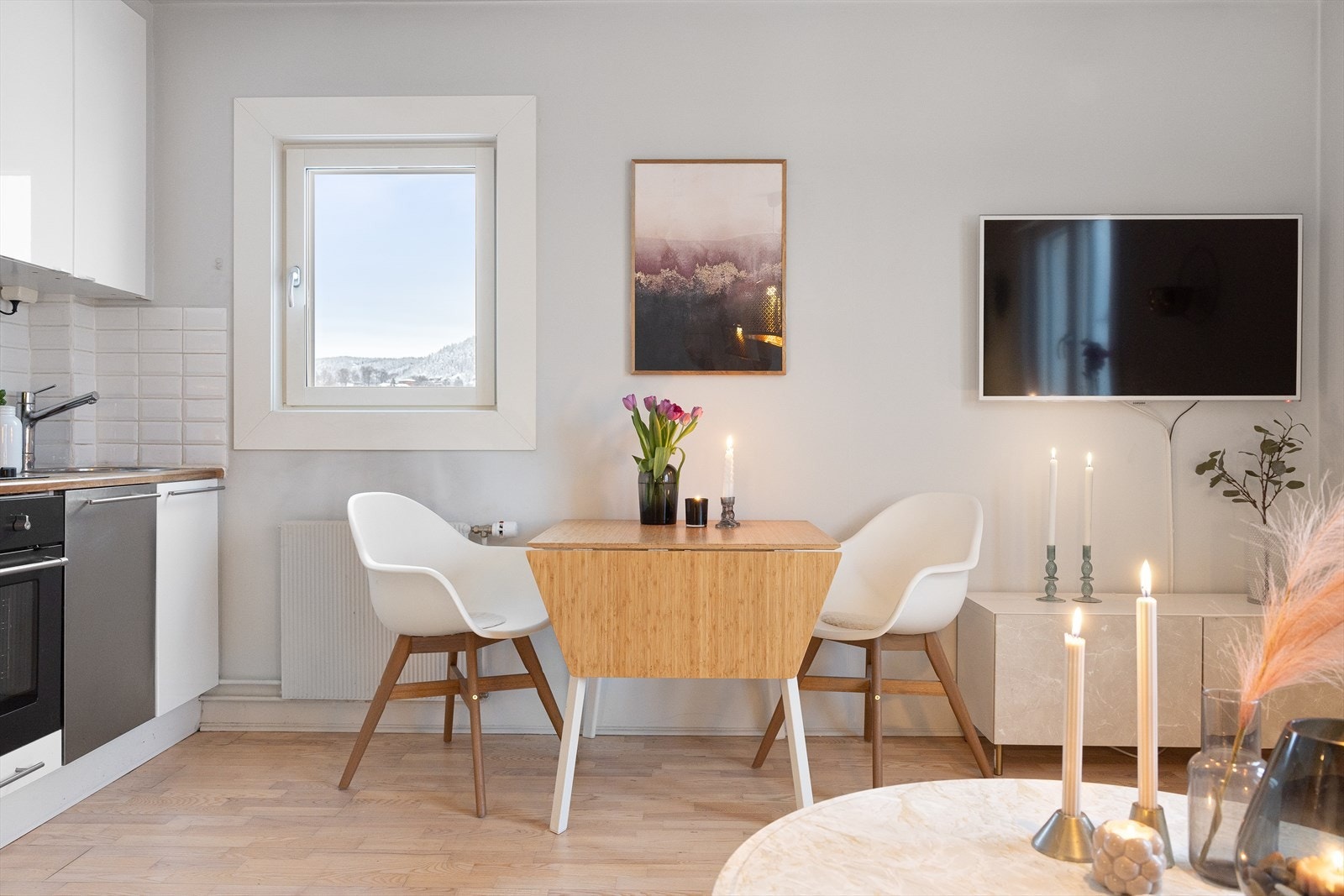 Det er også plass til et hyggelig spisebord, perfekt for måltider med familie eller venner, og gir rom for å invitere gjester på besøk. Galleribilde