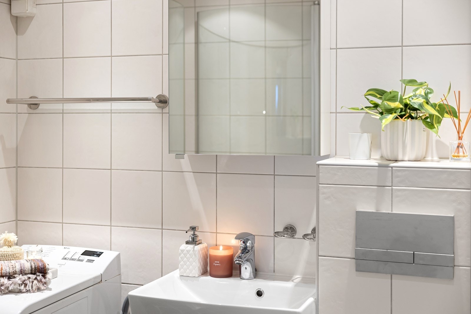 Badet har vegghengt klosett, servant med innredning, speil med belysning og dusjhjørne med svingbare glassdører. Galleribilde