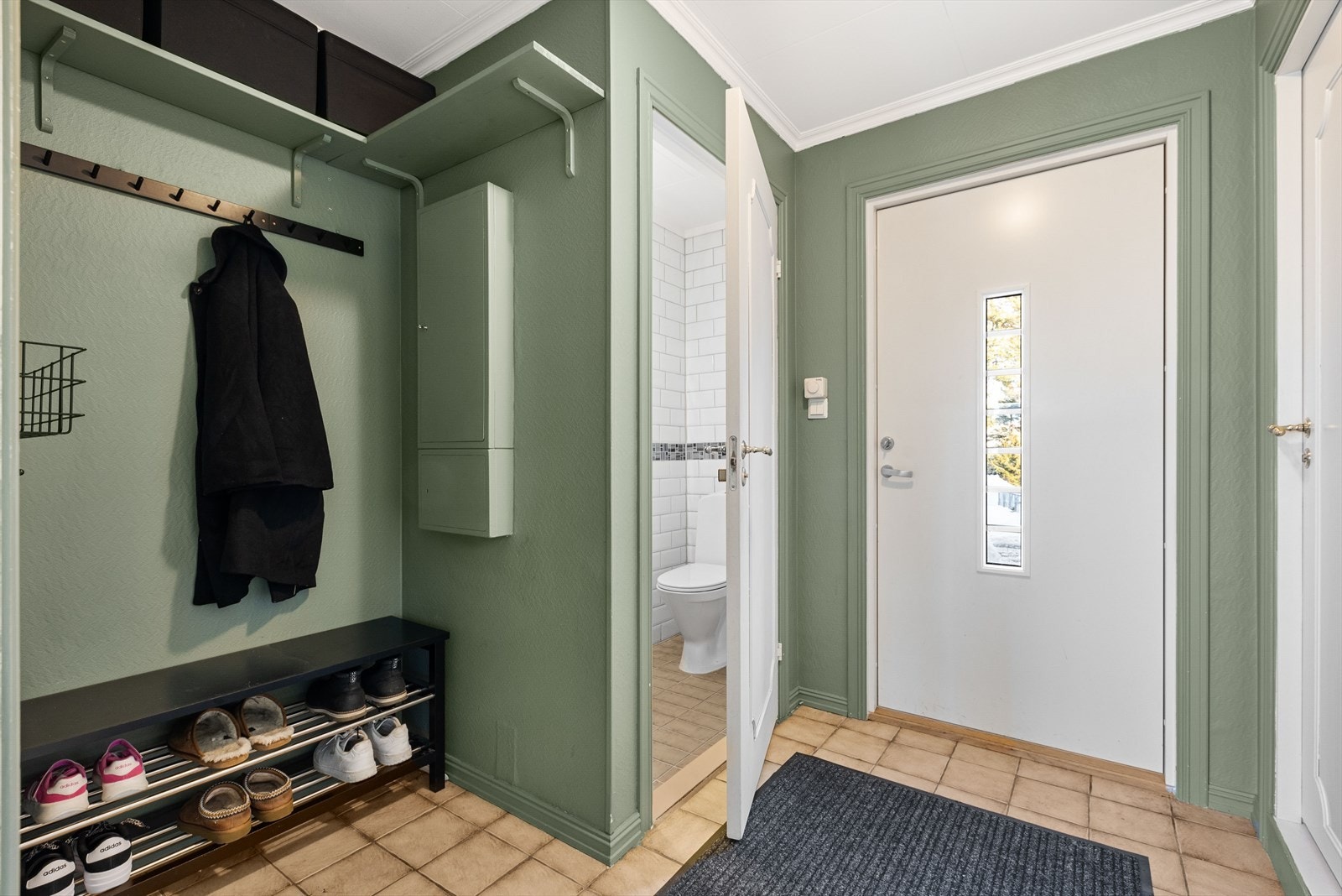 Velkommen inn i en romslig og innbydende entré med flislagt gulv Galleribilde