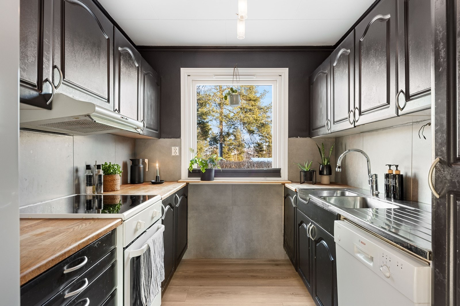 Kjøkkeninnredning med sorte, profilerte fronter og heltre benkeplate Galleribilde