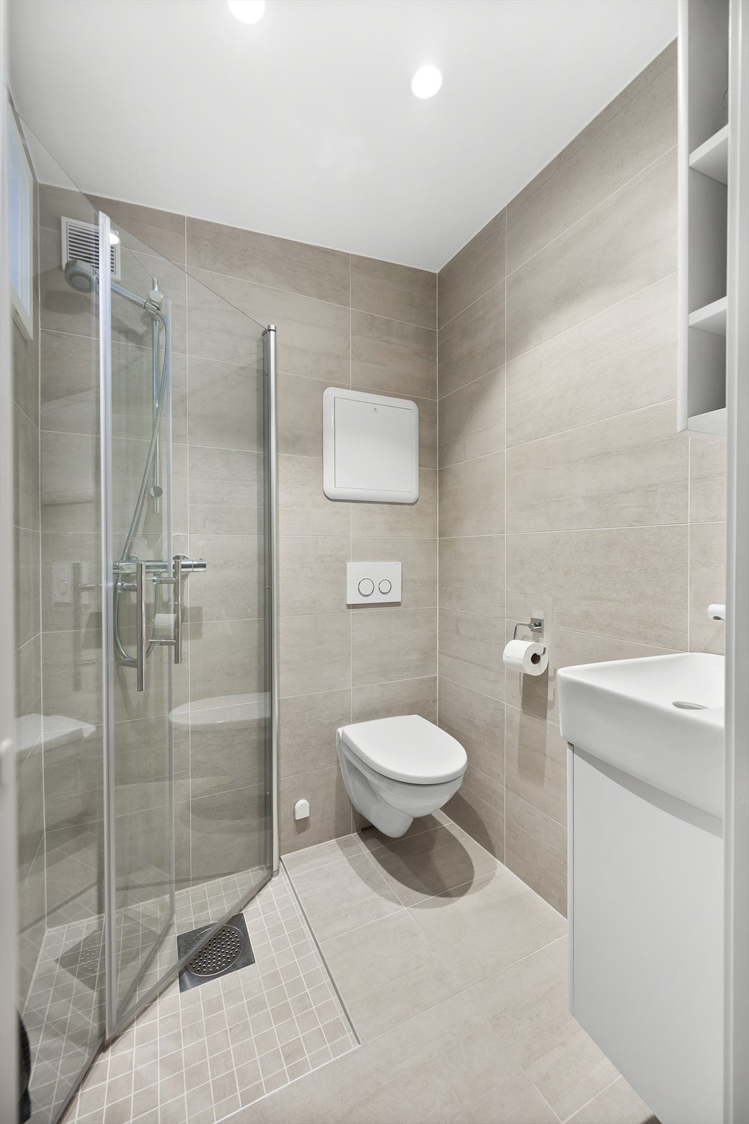 Baderom fra 2018 (opplyst i forrige salgsoppgave). Flislagt baderom innredet med vegghengt toalett, servant nedfelt i innredning og dusjhjørne med svingbare glassdører. Elektrisk gulvvarme. Galleribilde