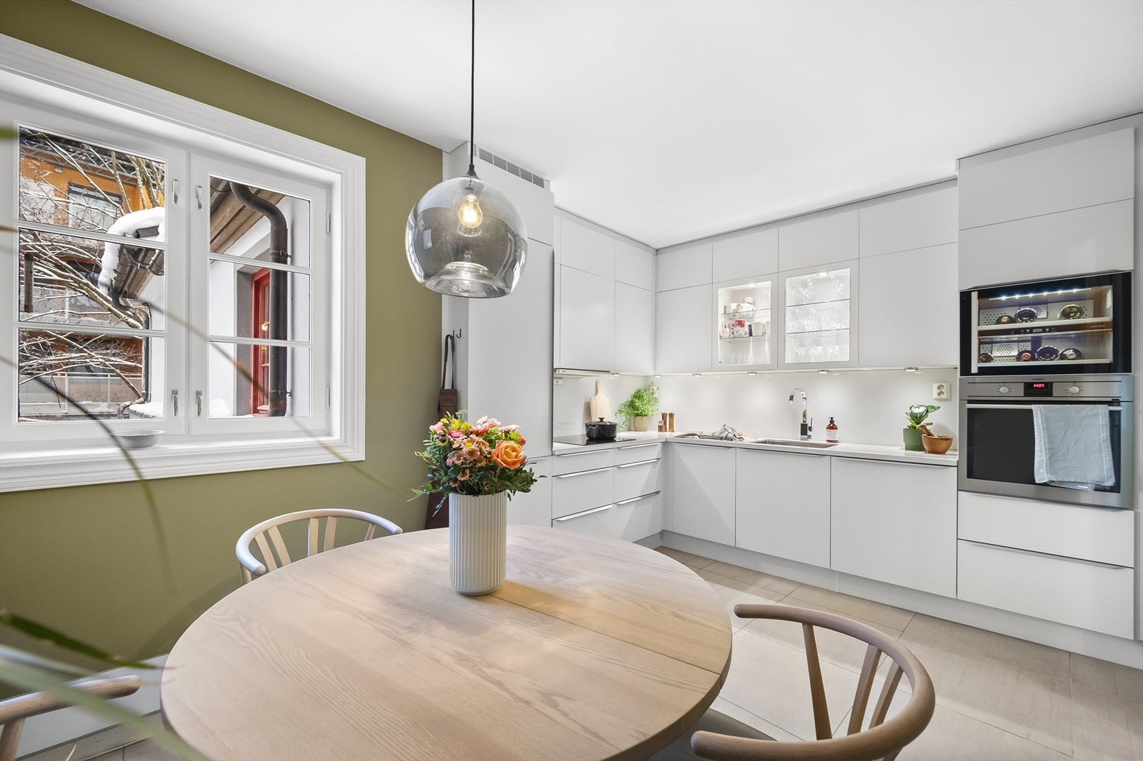 Kjøkkenet er malt i en lun og harmonisk grønnfarge, som står i stil med det moderne kjøkkenet. Galleribilde