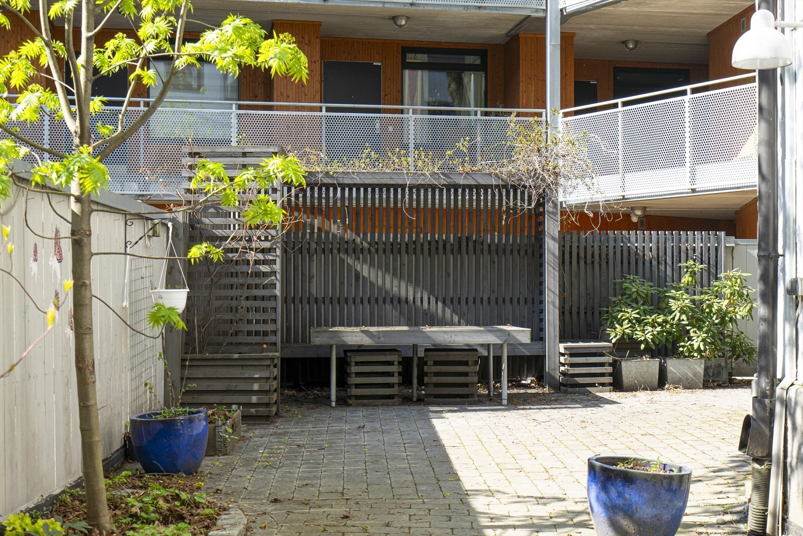 Bakgården er opparbeidet med flere sittegrupper og beplantning med både trær og blomster. Galleribilde