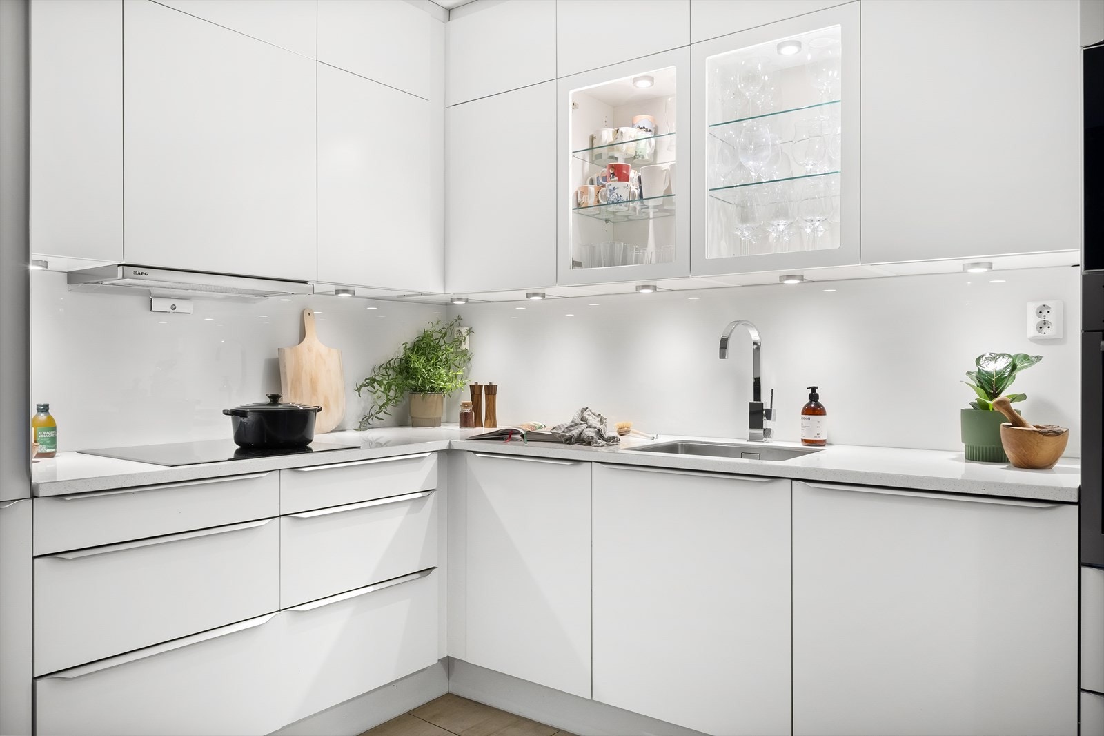 Kjøkkeninnredning fra HTH med glatte fronter. Benkeplate av stein med nedfelt vask. Galleribilde