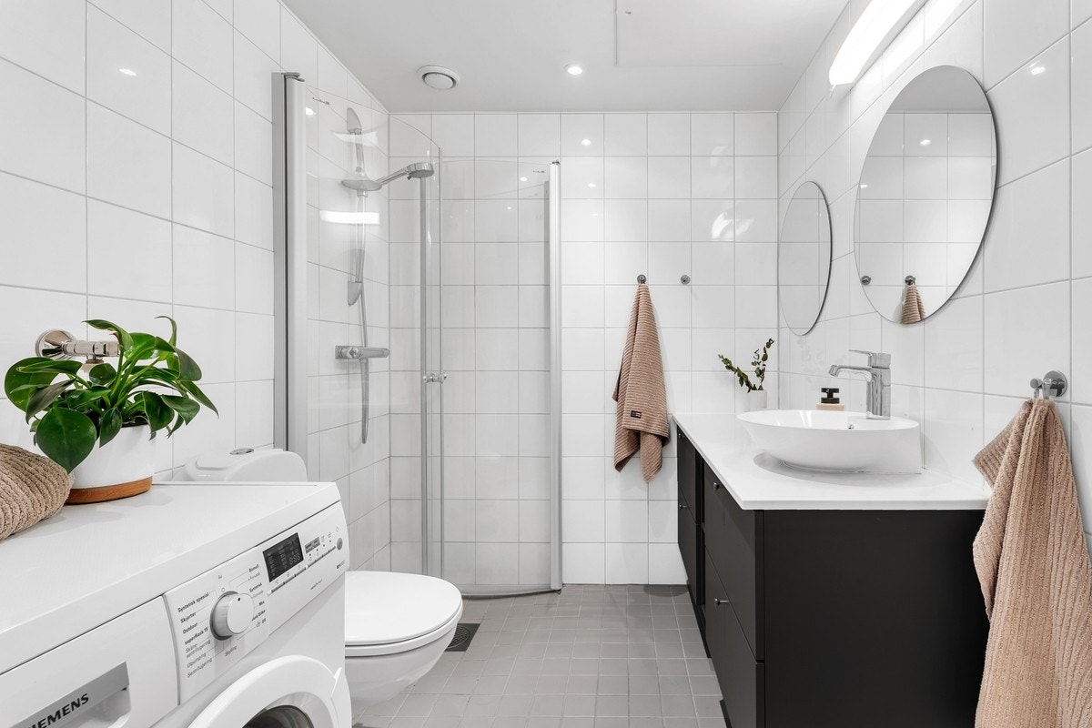 Badet har flislagt gulv med gulvvarme og flislagte vegger. I tillegg er det opplegg for vaskemaskin. Galleribilde