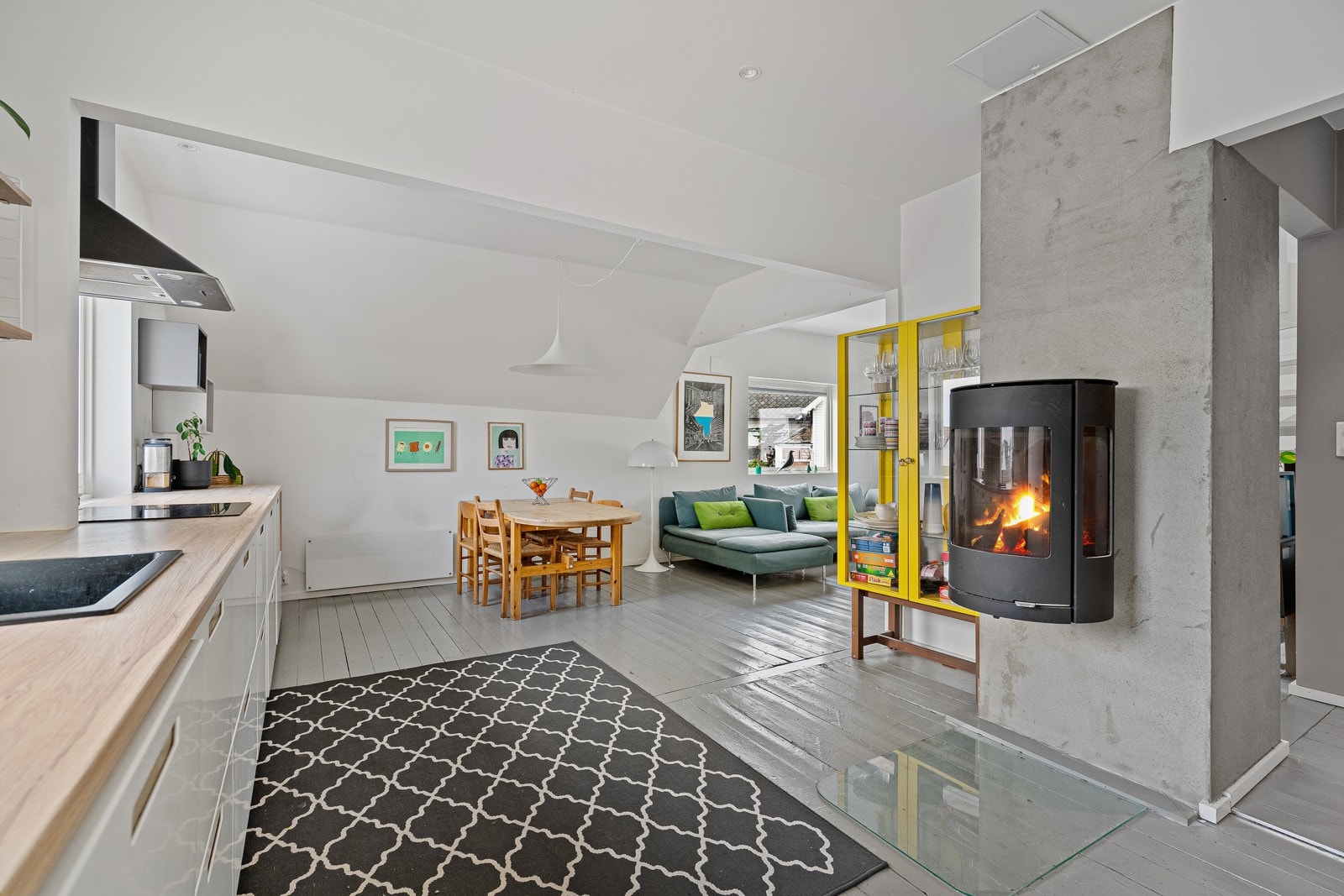 Nyt varme og hygge fra peisen som skaper en lun atmosfære i stuen. Galleribilde