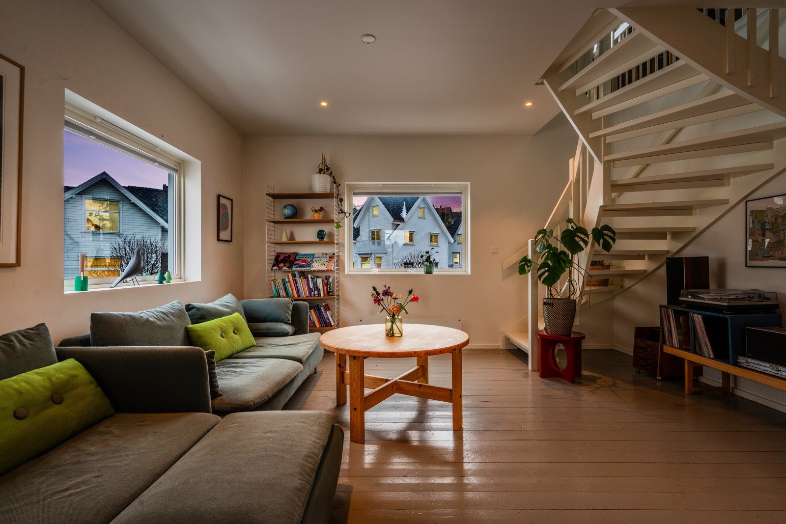 Stuen er utstyrt med en lun sofakrok hvor du kan nyte kveldene. De varme detaljene og de store vinduene gjør dette til et favorittsted i boligen. Galleribilde