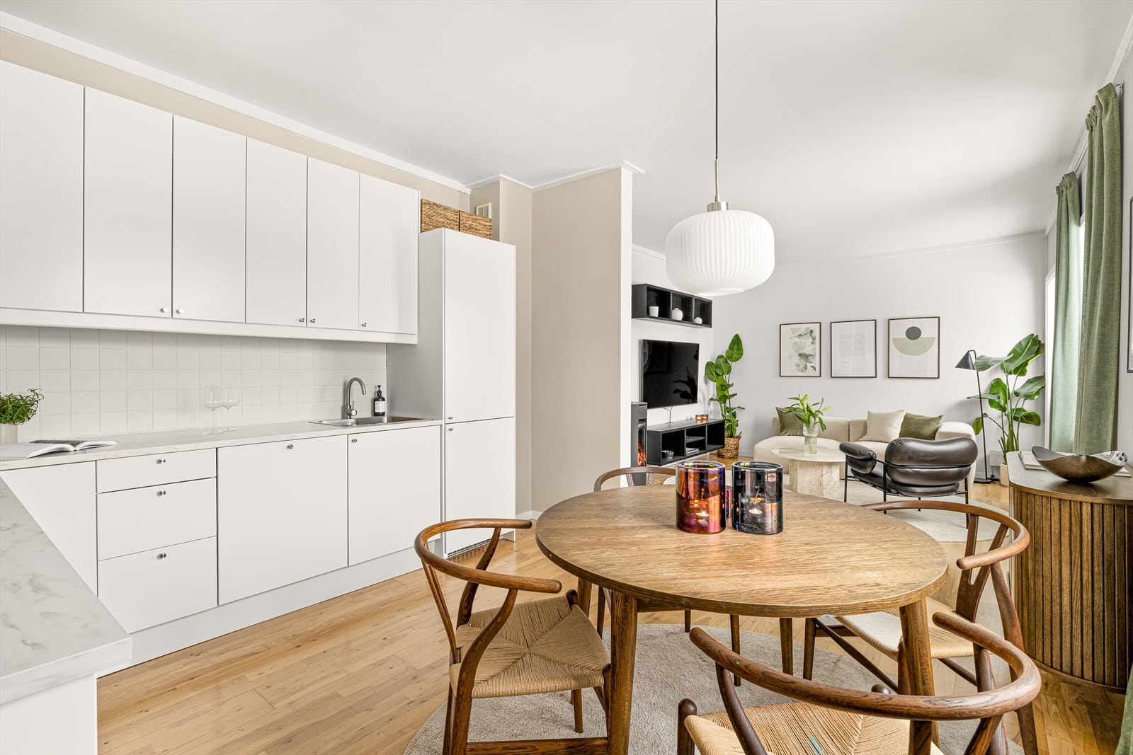 Innredningen består av hvite fronter. Benkeplatene i mørkegrå laminat har en overlimt dobbel kum med avrenningsfelt. Over benken er det hvite fliser som matcher innredningen, og en fritthengende ventilator fra 2019. Galleribilde