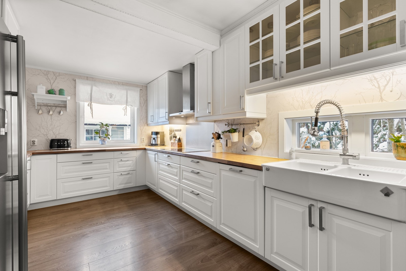 Kjøkkenet er tidløst med profilerte fronter, samt fire fronter med glassfelt og benkeplater av heltre. Galleribilde