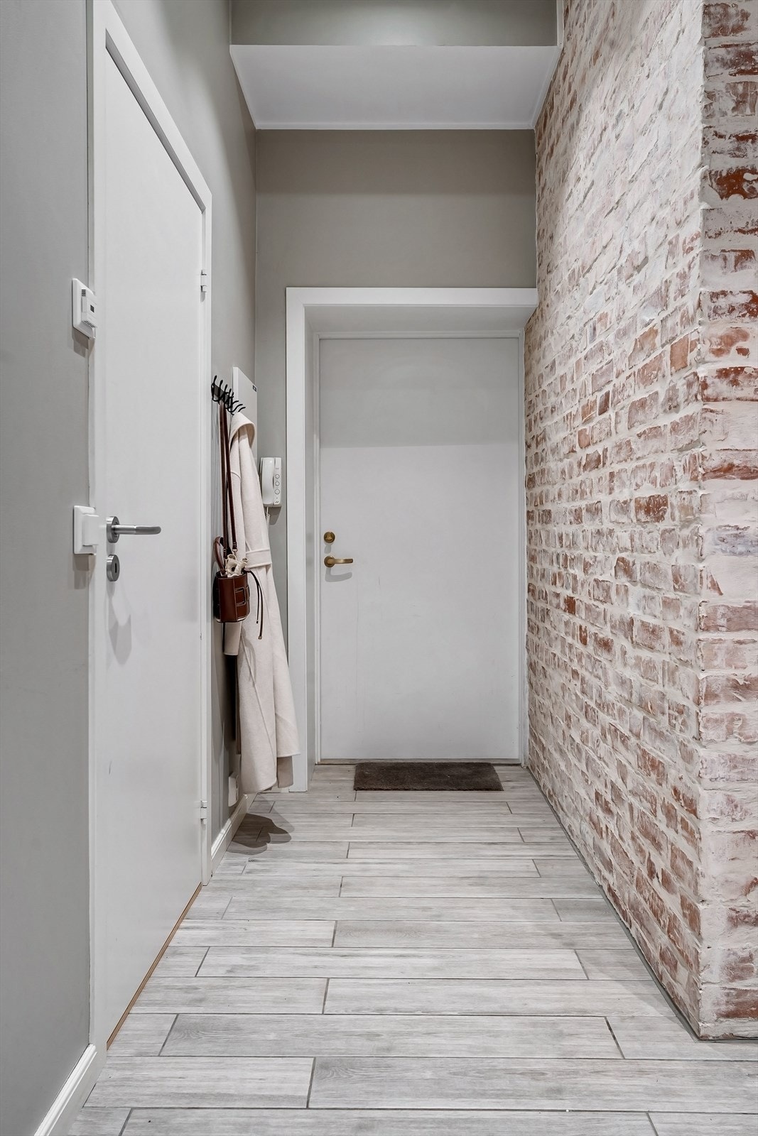 Lys entré med plass til å henge fra seg ytterklær og skotøy. Galleribilde