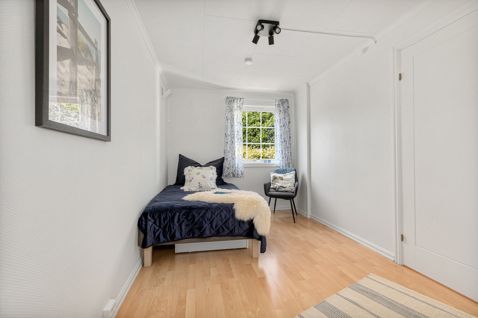 Videre inn befinner det seg et soverom med gode vindusflater og god plass for seng med tilhørende møblement. Galleribilde